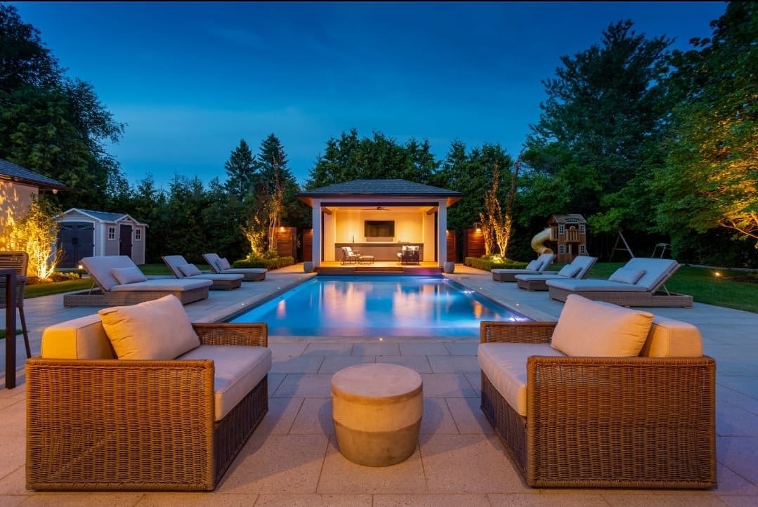 Pool and illuminated pavilion at night