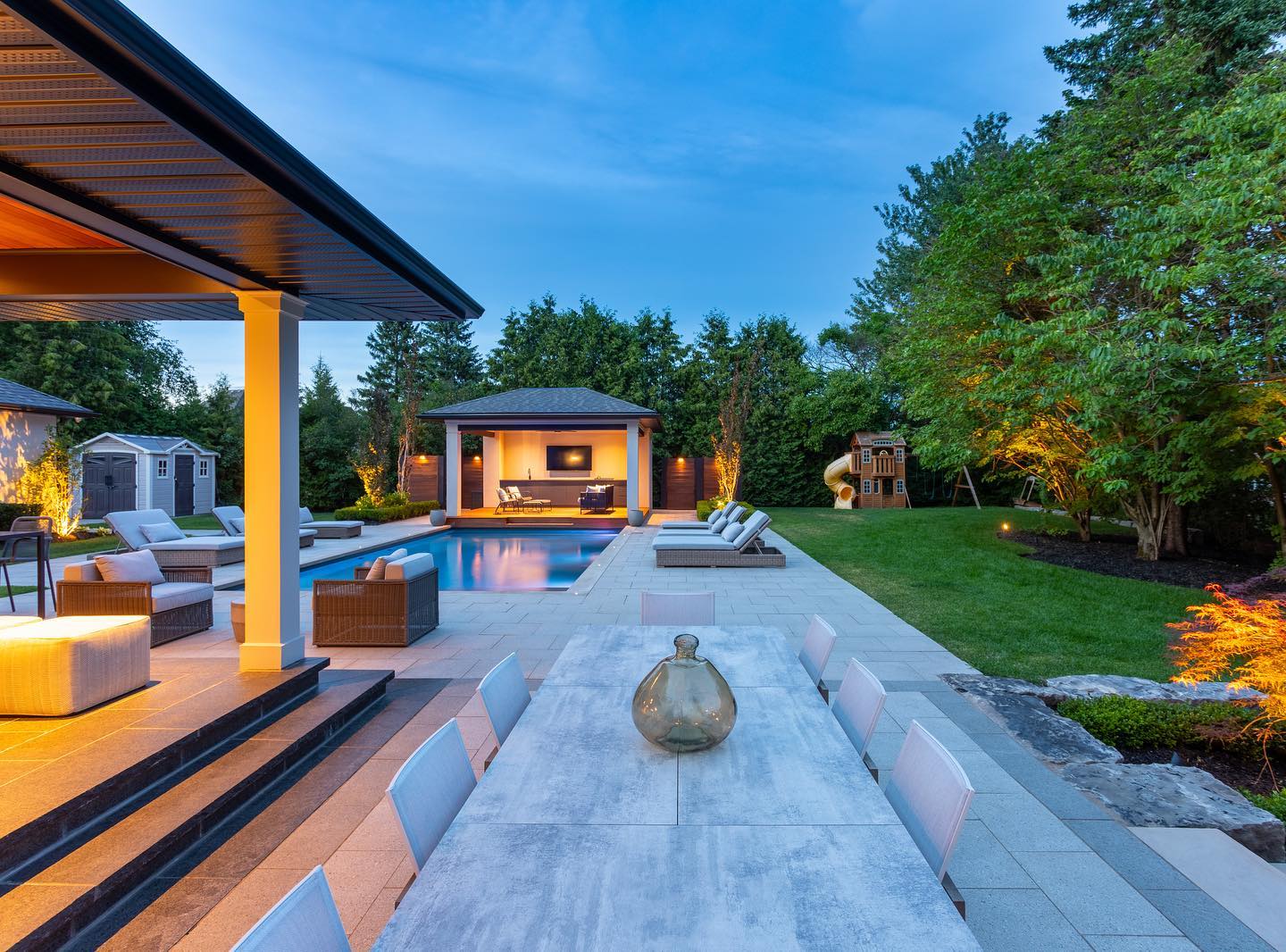 Outdoor dining overlooking the pool at dusk