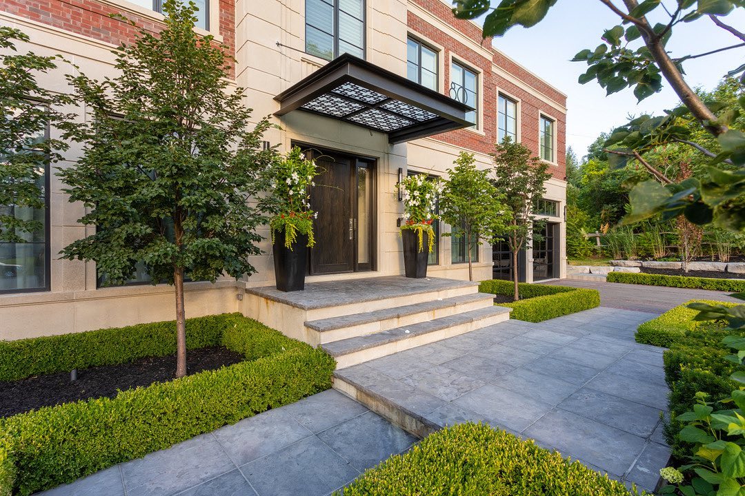 Stone entrance steps framed by clipped hedges